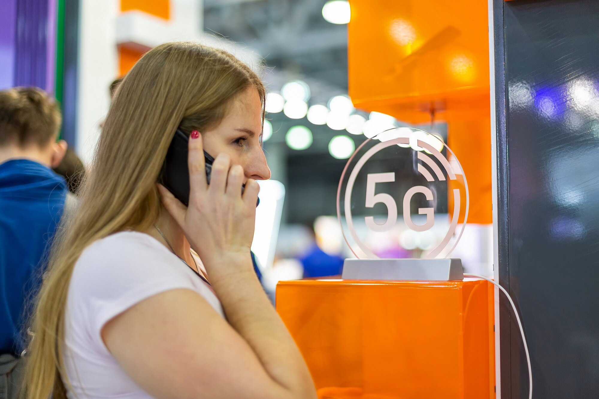 Młoda kaukaska dziewczyna rozmawia przez smartfon za pomocą ikony 5g