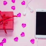 Pudełko i smartfon na różowym tle Biurko na prezent na dzień kobiety
