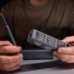 Osoba demonstrująca precyzję za pomocą narzędzi naprawiających skomplikowane elementy elektroniczne