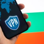 VPN w Bułgarii Koncepcja bezpiecznego i bezpiecznego Internetu Prywatność Ręka z telefonem komórkowym i aplikacją VPN Flaga i laptop na zdjęciu w tle