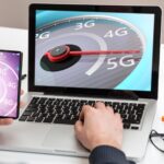 Prędkościomierz szybkiego połączenia sieciowego 5G na tle biura biznesowego na ekranie laptopa komputera