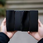 Nowoczesne smartfony z pustym ekranem w ręku i izolowane na kolorowym tle