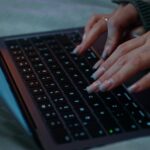 Kobieta używa laptopa siedząc na łóżku
