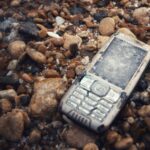 połamany i utopiony telefon na kamieniach w morzu