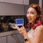 Szczęśliwa studentka przekazuje plastikową butelkę z napojem do recyklingu do zautomatyzowanej maszyny Przyjazny dla środowiska styl życia i zwrot gotówki