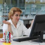 Naukowiec pracujący nad laptopem przy stole